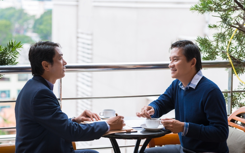 Discussion professionnelle entre deux hommes au Vietnam.
