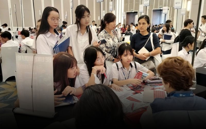 Étudiants et jeunes diplômés échangeant avec des recruteurs lors d’un salon de l’emploi au Vietnam.