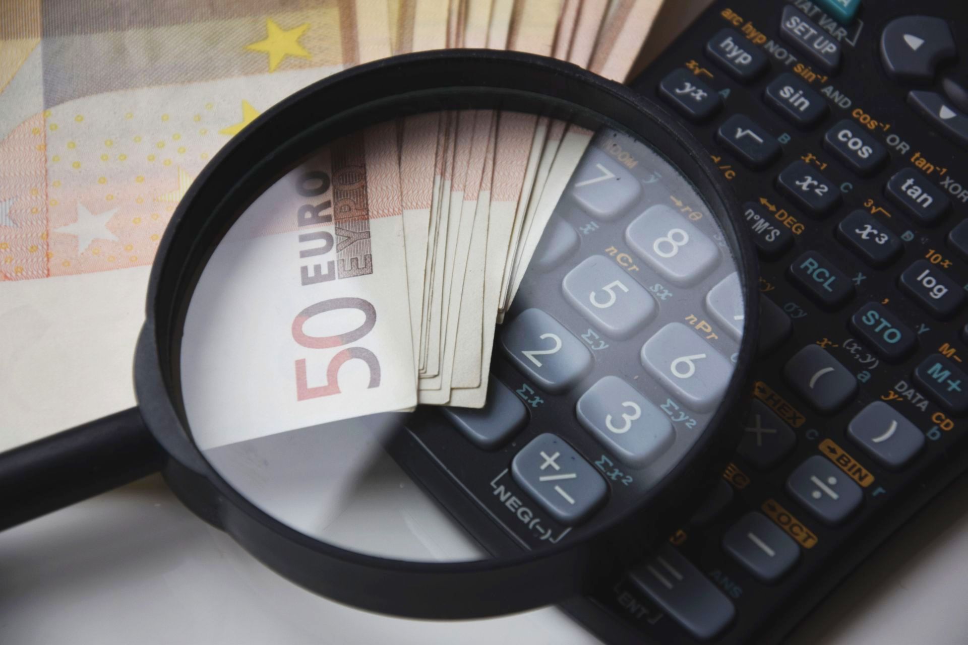 Billets et calculatrice examinés à la loupe.
