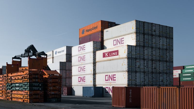 Conteneurs empilés dans une zone portuaire.