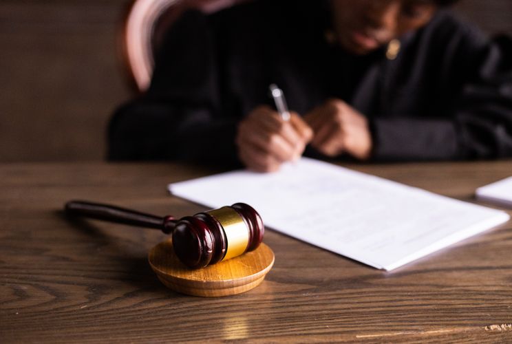 Professionnel examinant un document juridique avec un marteau de juge.
