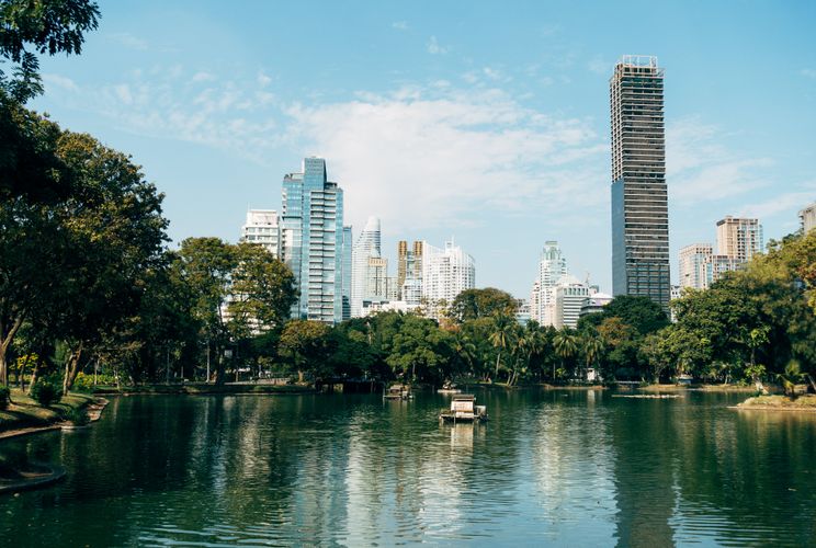 View of Bangkok’s urban skyline from a park.