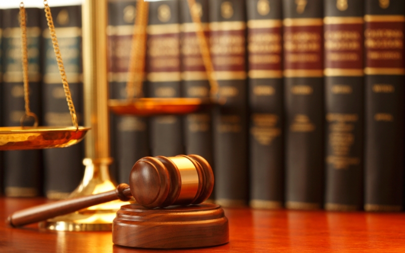 Marteau de juge et livres de droit dans un cabinet juridique.