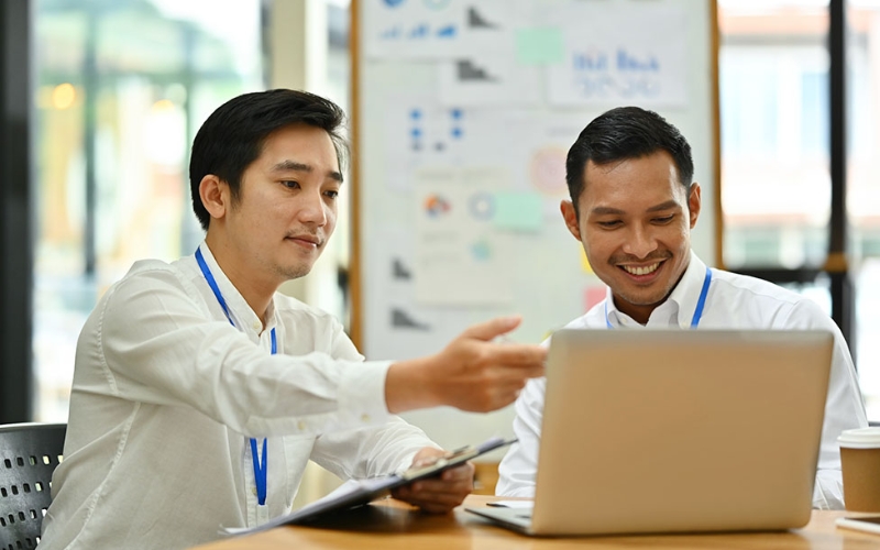 Professionnels discutant autour d’un ordinateur au Cambodge.