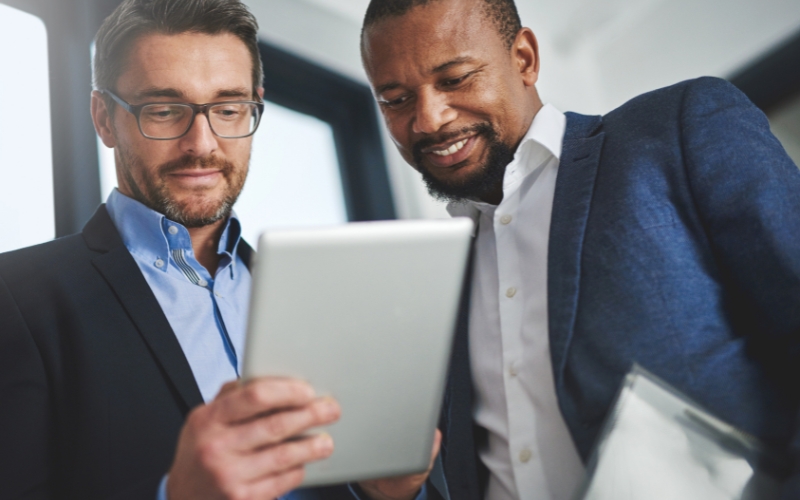 Professionnels consultant des informations financières sur tablette.